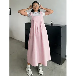 Modèle portant une robe chasuble à rayures roses grande taille et t-shirt blanc