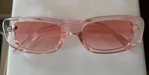 Primo piano di occhiali da sole quadrati alla moda con montatura rosa trasparente