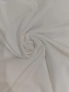 Detailed macro view of the soft white textile fabric used in elegant midi dresses
