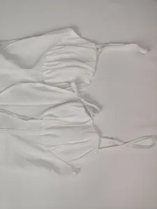 Close-up detail of the ruched bust and adjustable thin straps on white elegant summer dress