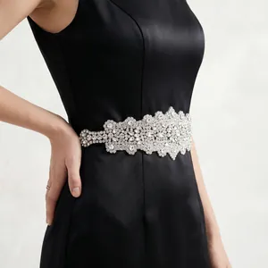 Elegant bridal sash featuring intricate floral rhinestone clusters on a black satin dress.