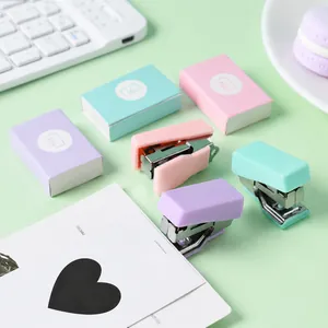 Primo piano di mini cucitrici color macaron con scatole di graffette coordinate