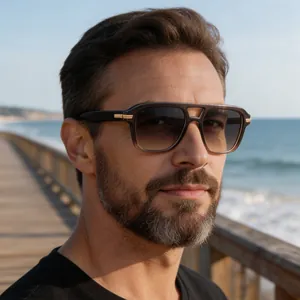 Close-up view of a man wearing classic square double-bridge sunglasses at the beach.