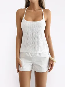 Close-up of a white Y2K style halter tank top with textured fabric and bead details.