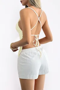 Back view of a yellow Y2K halter top with criss-cross straps and back tie detail