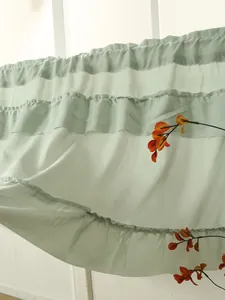 Detail of sage green ruffled tiered curtain showing texture and layers