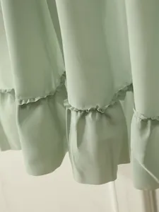 Detail of elegant ruffle edge on a light green curtain with soft drape texture