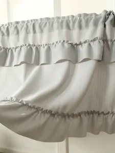 Detail view of white ruffled cake skirt curtain with elegant layered fabric texture