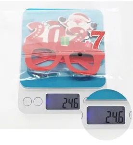 Detailansicht der 2027 Weihnachtsmann-Brille mit einem Gewicht von 24,6 g auf der Waage.
