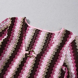 Detailed close-up view of a V-neck dress featuring colorful zigzag patterns and gold ring accents