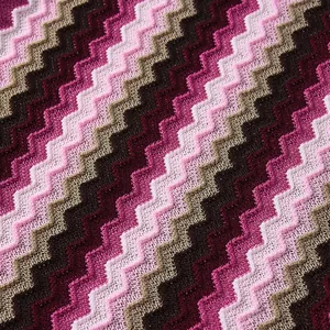 Detailed macro view of colorful chevron knit fabric pattern in purple and brown tones