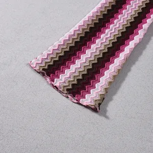 Detailed view of the vibrant zigzag knit pattern and texture on this autumn dress sleeve.