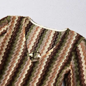 Detailed view of the V-neckline with a gold ring buckle on a colorful zigzag knit dress.