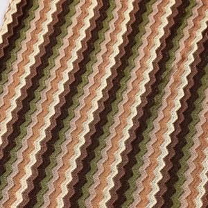 Detailed close-up of a multicolor zigzag chevron knitted fabric for women's autumn dress.