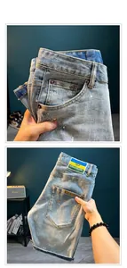 Detailed view of men's distressed denim shorts with paint splatter and abrasions.