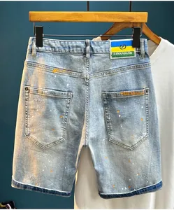 Close-up of high street men's denim shorts featuring unique hand-painted splatter details