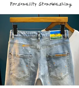 Detailed view of high street denim shorts with paint splatter and distressed effects.