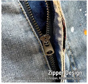 Close-up of durable metal zipper on blue denim shorts with paint splatter detail