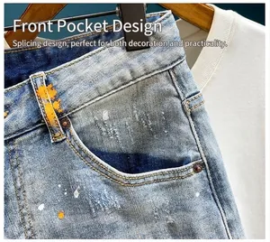 Detail of front pocket design on distressed denim shorts with paint splatter