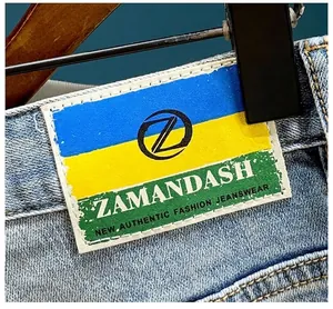 Close-up detail of the colorful brand patch on distressed high street denim shorts