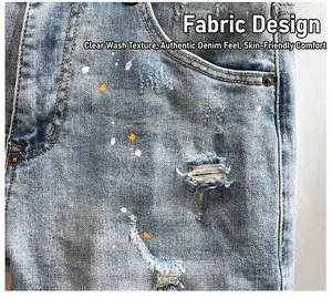 Close-up of light blue distressed denim shorts featuring artistic paint splatters and rips.