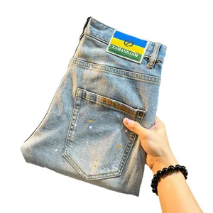 Men's light blue distressed denim shorts with artistic paint splatter and stretch fit