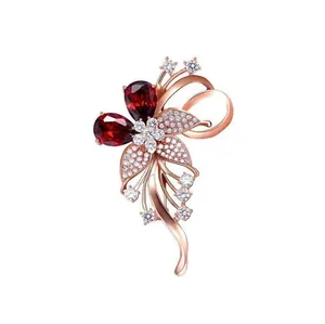Broche fleur élégante en or rose avec pierres précieuses rubis et cristaux étincelants