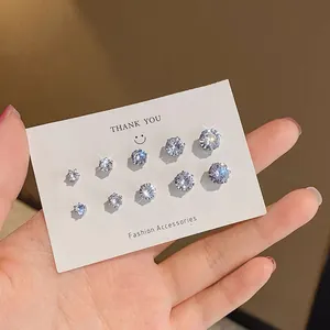 Close-up detail of several pairs of sparkling white zircon stud earrings on a card