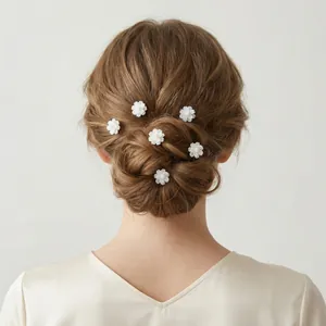 Detailed view of elegant white floral hair pins styled in a professional bridal bun