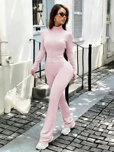 Full-body street view of a woman in a pink Y2K yoga jacket and flared pants set