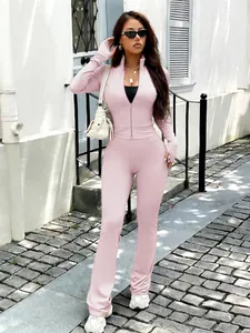 Model wearing a pink Y2K zip-up yoga jacket and flare leggings set in a street setting