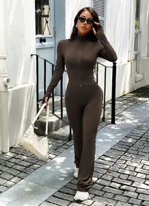 Chic brown Y2K yoga set featuring a zip-up jacket and flared pants on a street model
