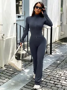 Two-piece charcoal grey yoga sportswear set with zip-up long sleeve top and flared leggings