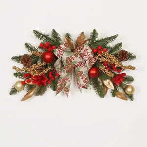 Addobbo natalizio festivo con bacche rosse, decorazioni dorate e un fiocco decorato