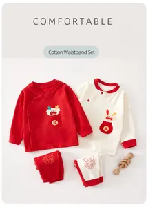 Détail de l'ensemble bébé nouveau-né en coton rouge et blanc avec motif dragon.