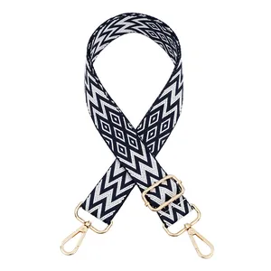 Detailed view of adjustable woven bag strap featuring geometric patterns and gold clips