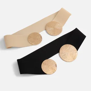 Detailansicht der elastischen Gürtel in Beige und Schwarz mit strukturierten Goldmetallplatten.