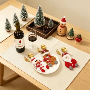 Feestelijke kerstbestekhouders met sneeuwpop rendier en kerstman op een eettafel