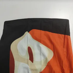 Close-up of vibrant orange and black abstract print fabric on a summer bandeau dress.