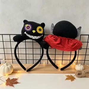 Close-up of Halloween black cat and vampire themed plush headbands on a wooden shelf