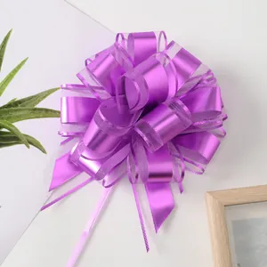 Detaillierte Makroaufnahme einer lila Geschenk-Ziehschleife aus Organza und Metallband.