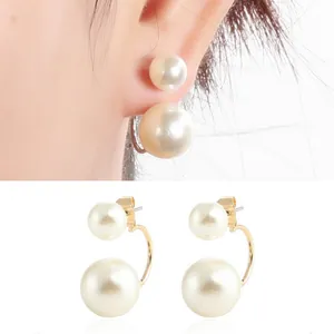Close-up of elegant front-back double pearl earrings with gold-tone C-shape design