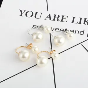 Detailed macro view showing gold and silver tone front-back curved faux pearl earrings