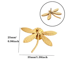 Detail view of golden dragonfly brooch with 35mm width dimension markings.