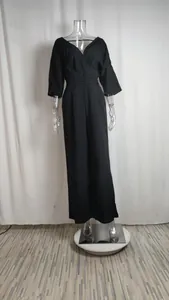 Detailed view of elegant black v-neck jumpsuit with waist pleats and wide leg style.