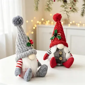 Detailaufnahme von zwei sitzenden Weihnachtswichteln mit Strickmützen und weißen Bärten.