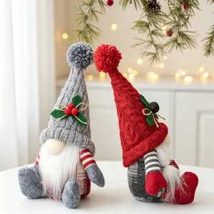 Zwei handgemachte Weihnachtswichtel mit grau-roten Strickmützen auf einem Tisch