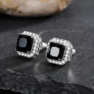 Close-up macro view of elegant square stud earrings with black stone and white halo stones
