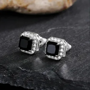 Close-up of elegant square stud earrings with black gemstone and halo setting