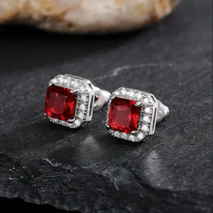 Close-up of elegant square stud earrings with red crystal and halo diamonds